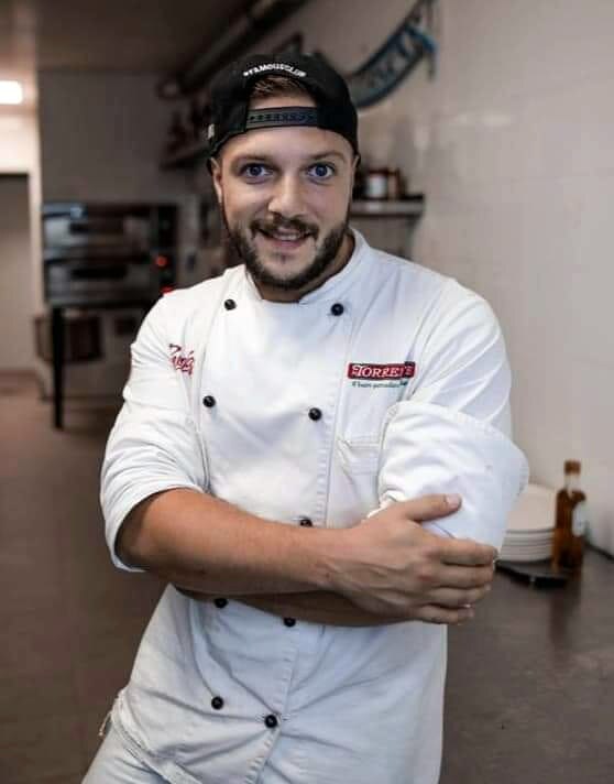 Chef slicing perfectly baked pizza