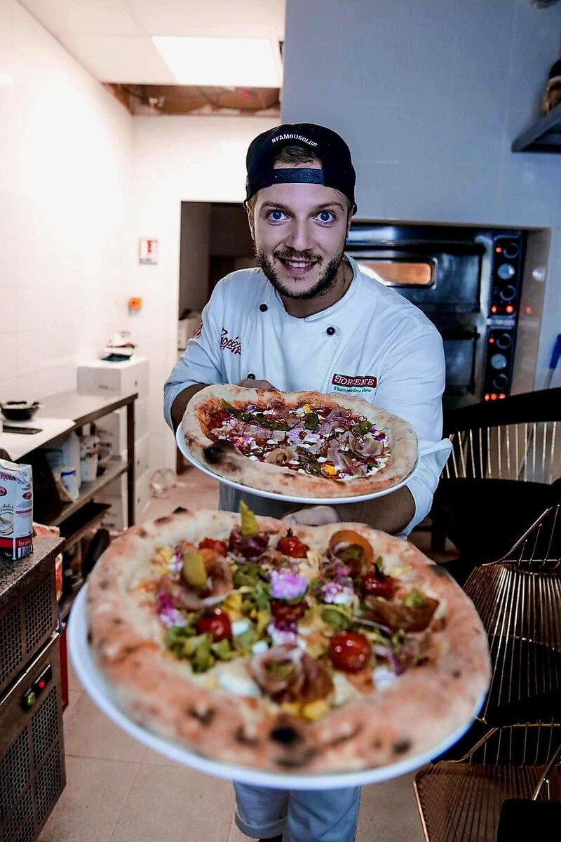 Chef Andrei presenta pizze autentiche appena preparate