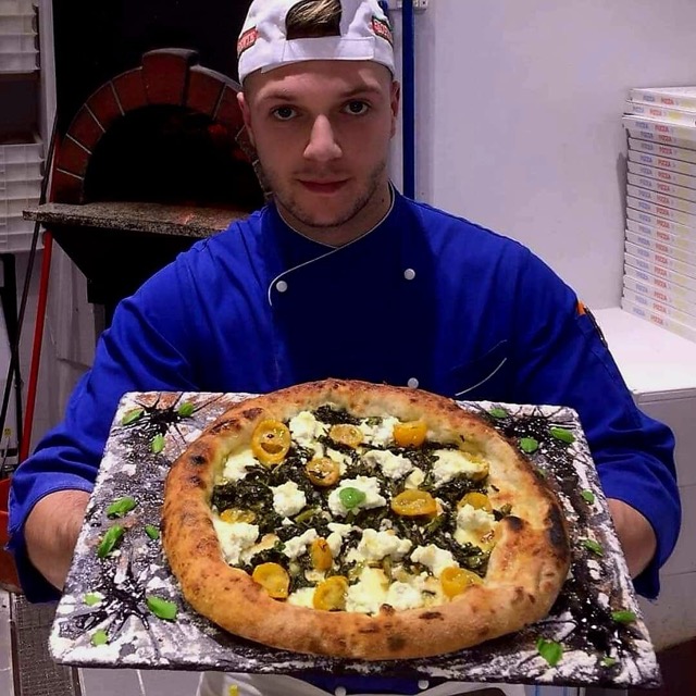 Chef serve una pizza su pietra tradizionale